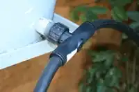 Figure 3: The T-fitting located at the storage bucket outlet splits the main water line to allow watering of multiple beds.