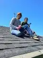 Klara and James on the roof ready to install gutter screen