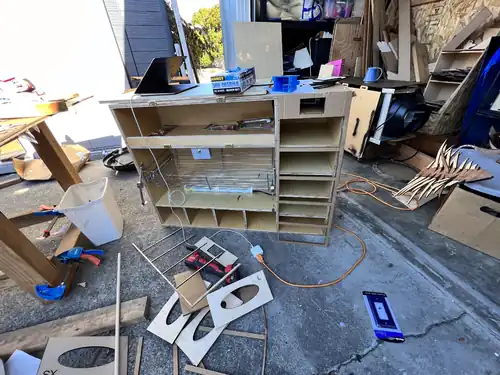 image showing the cardboard lasercut glove box cover being checked against the cabinet before the piece is cut out of wood.
