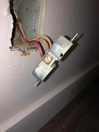 outlet with 2 white wires attached to 1 screw on right of outlet with 1 red wire attached to 1 screw on left of outlet