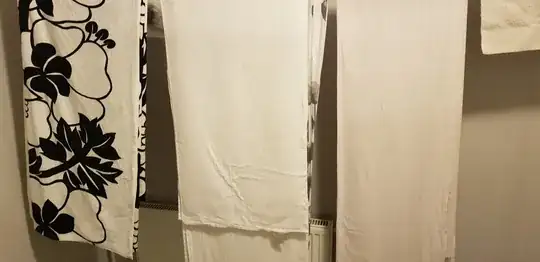 A number of hung up bed linens with wrinkles and creases