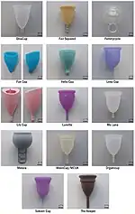 Scale images of 14 different menstrual cups, most bell shaped, two goblet-shaped (a sort of three-quarter-spherical bowl), two with smooth outsides and an asymmetrical thin-membrane turned-in lip, most with cylindrical stems, one with a loop, one with a ladder-like strip of loops, one with no stem.