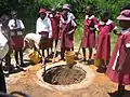 School children in Zimbabwe digging a shallow pit for an Arborloo toilet (a variation of a pit latrine), Epworth in Harare, Zimbabwe.