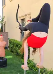 Sofie Dossi's outie belly button while she prepares to shoot a bow