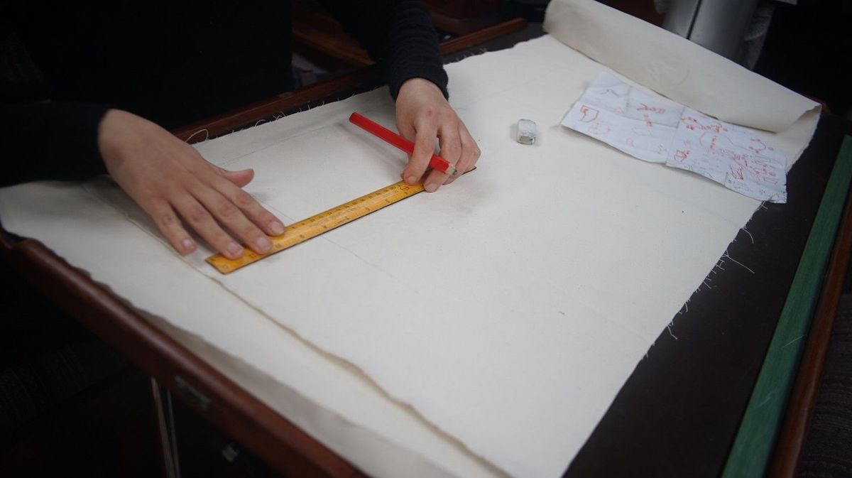 someone drawing a pattern on fabric