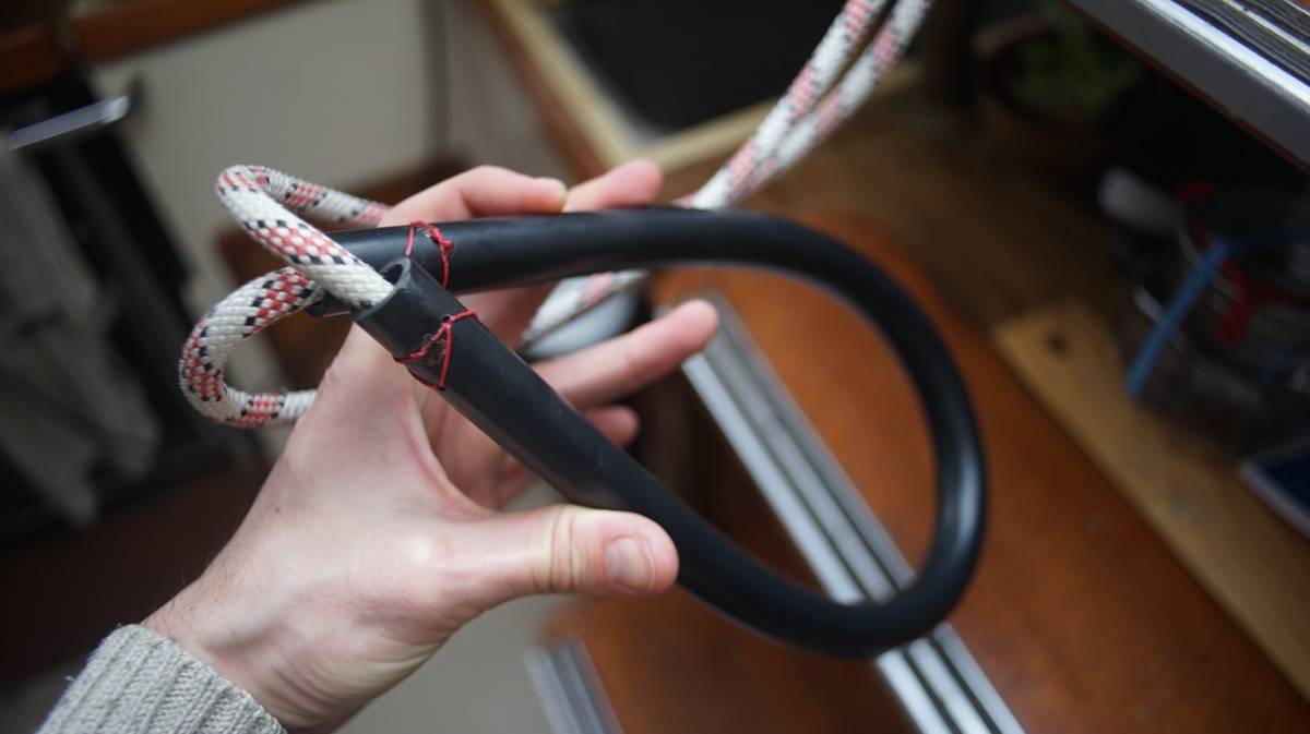 a piece of black tubing with a rope running through it