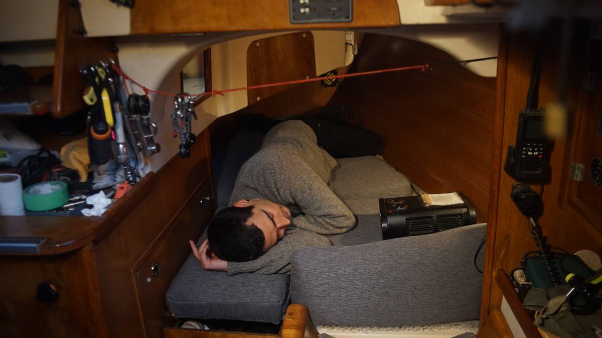 devine laying on the finished quarter berth cushions, looking comfy