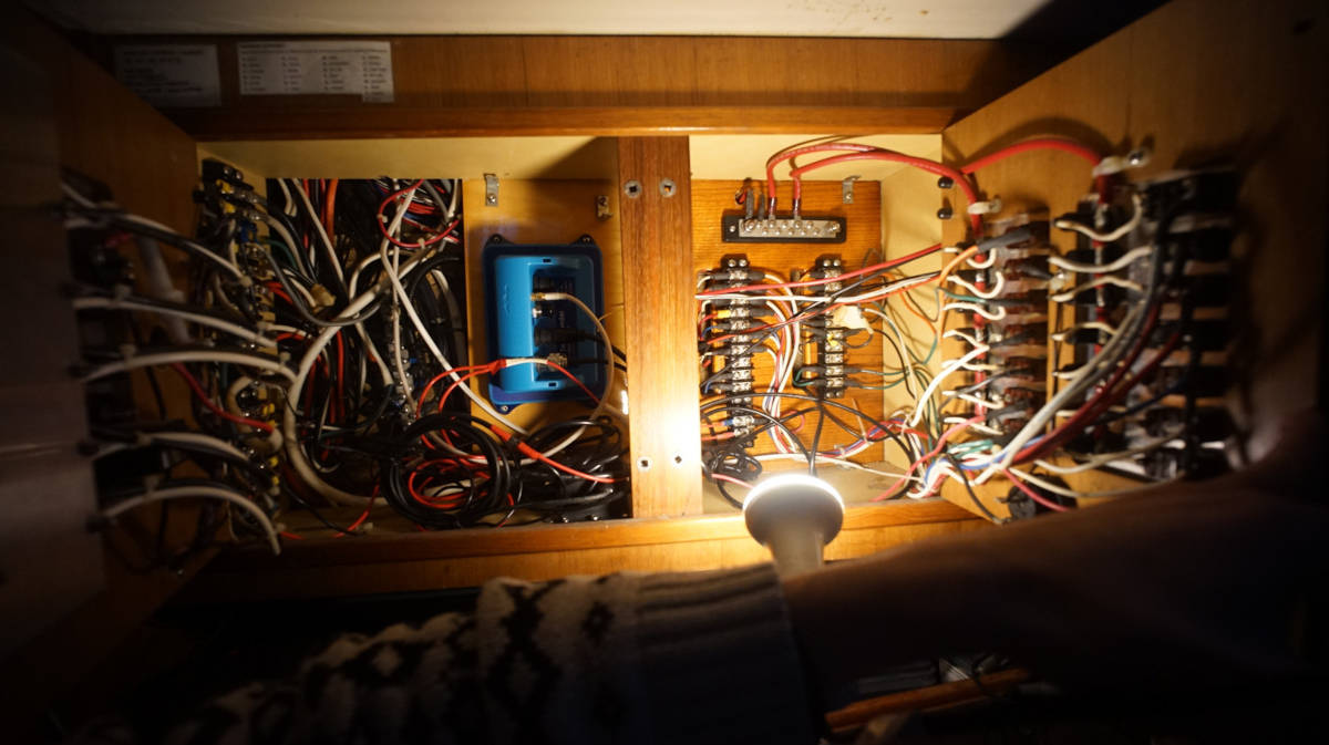 a photo of a complex and mess network of wiring behind the breaker panel