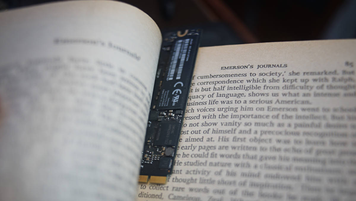 an open book with an ssd used as a bookmark