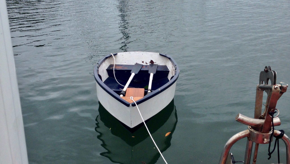 A photo of Devine rowing a wooden dinghy