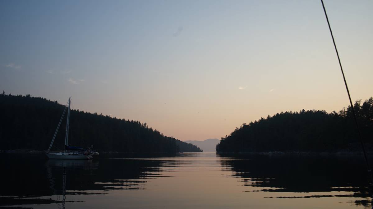 boats at anchor in ballet bay under a pink sky in the late evening