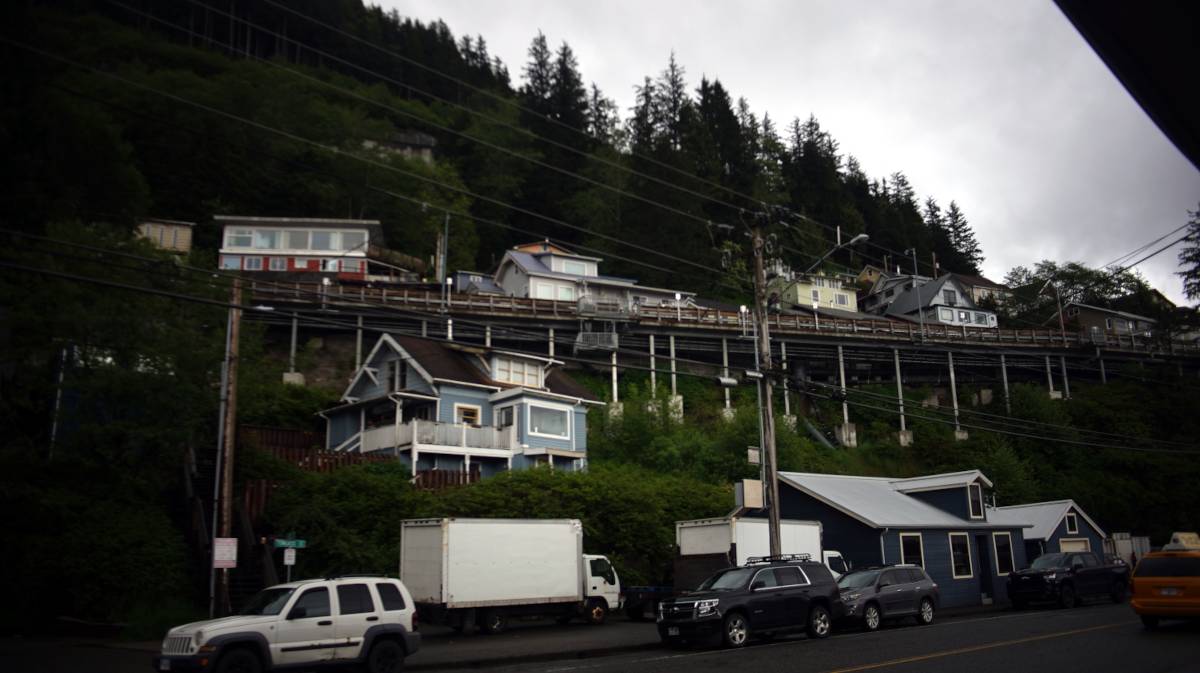 houses perched up on a cliffside with long wooden staircases leading to them