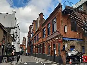 Barley Mow Passage, Voysey House and Devonshire Works. The tower of the Catholic church is in the background.