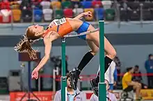 Photo of Britt Weerman in the air jumping over a bar
