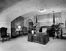 black and white image of the Resolute desk in the White House broadcast room