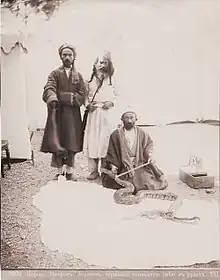 Persian dervish, holding a huge snake in his arms (1870s)
