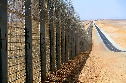 Image 9A more recent section of the Israel-Egypt barrier fence, north of Eilat, June 2012. It is a border barrier built by Israel along its border with Egypt. It was originally an attempt to curb illegal migrants from African countries. Construction was approved on 12 January 2010 and began on 22 November 2010.
