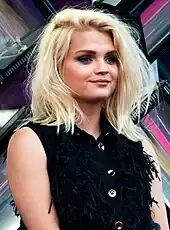 Smiling blonde woman in a sleeveless black top.