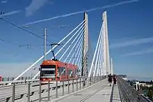 A view of the Tilikum Crossing bridge from the pedestrian and bicycle lane with a streetcar passing by