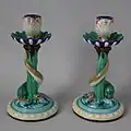 Candlesticks, coloured glazes, moulded in relief, circa 1880, naturalistic in style with historical references.