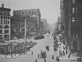First Avenue looking north from James Street in 1916 with the Pioneer Square pergola and totem pole bordered by the Pioneer Building (far right) and Mutual Life Building (far left).