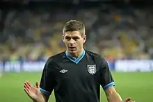 Gerrard warming up in a black England shirt