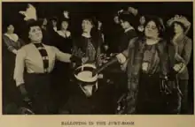 A photograph depicts the first woman jury in America casting their ballots into a hat