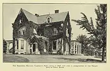 Photograph of a two-and-a-half story house.  Much of the structure is covered with ivy, giving the impression of age.