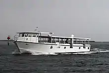 a white ferry boat sails across dark blue waters