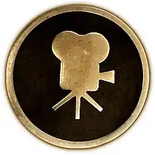 Circular 4-inch brass plaque showing a side view of a classic movie camera.